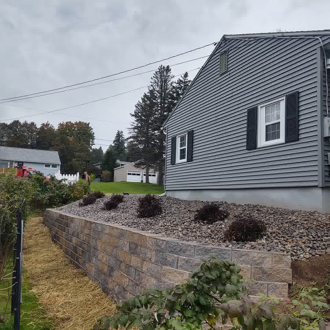A beautiful retaining wall done by our crew with fresh rocks and plants installed as well.