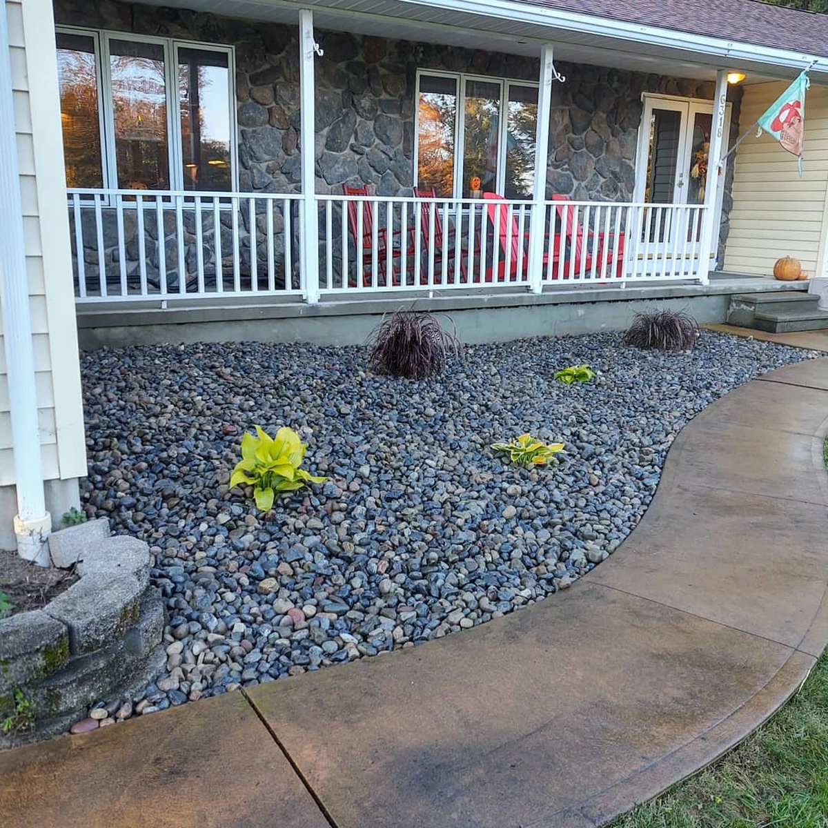 Patio with stamped concrete and river rock landscaping, ideal for low-maintenance hardscaping.