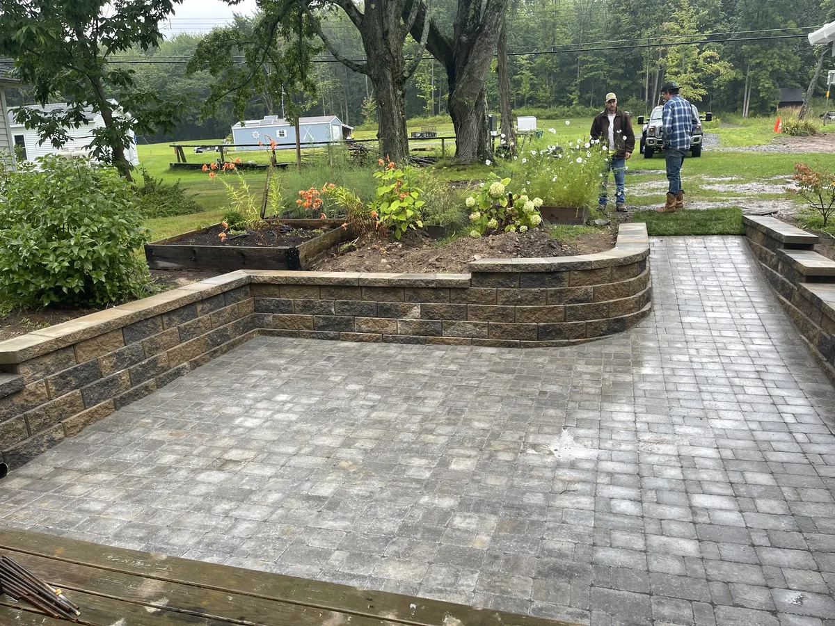 Landscaped gravel walkway bordered by mulch beds and greenery, leading to backyard garden shed.
