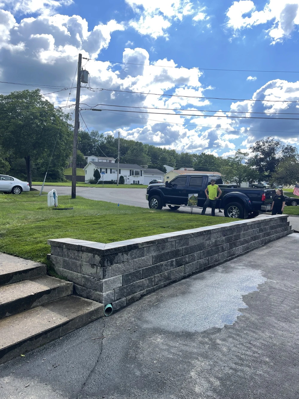 Retaining wall and yard grading showing drainage planning for patios and walkways before harsh Utica winters.